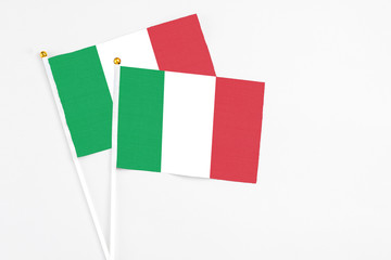 Italy and Italy stick flags on white background. High quality fabric, miniature national flag. Peaceful global concept.White floor for copy space.