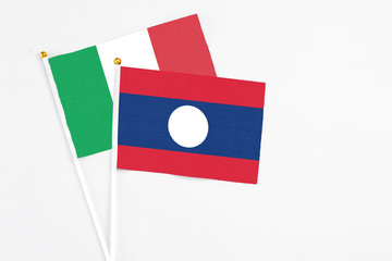 Laos and Italy stick flags on white background. High quality fabric, miniature national flag. Peaceful global concept.White floor for copy space.