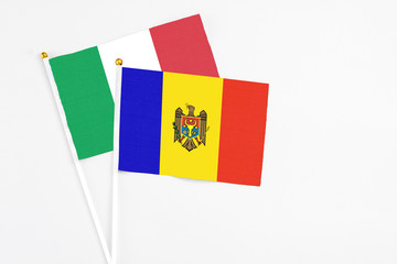 Fototapeta premium Moldova and Italy stick flags on white background. High quality fabric, miniature national flag. Peaceful global concept.White floor for copy space.