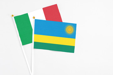 Rwanda and Italy stick flags on white background. High quality fabric, miniature national flag. Peaceful global concept.White floor for copy space.