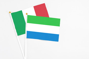 Sierra Leone and Italy stick flags on white background. High quality fabric, miniature national flag. Peaceful global concept.White floor for copy space.