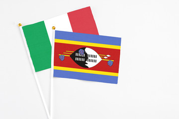 Swaziland and Italy stick flags on white background. High quality fabric, miniature national flag. Peaceful global concept.White floor for copy space.