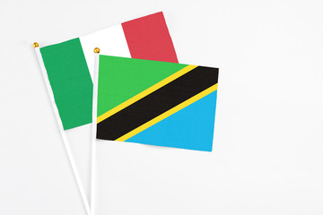Tanzania and Italy stick flags on white background. High quality fabric, miniature national flag. Peaceful global concept.White floor for copy space.