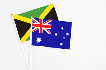 Australia and Jamaica stick flags on white background. High quality fabric, miniature national flag. Peaceful global concept.White floor for copy space.