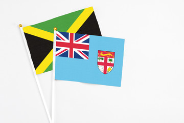 Fiji and Jamaica stick flags on white background. High quality fabric, miniature national flag....