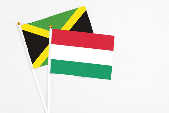 Hungary and Jamaica stick flags on white background. High quality fabric, miniature national flag. Peaceful global concept.White floor for copy space.