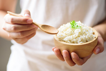 Hand holding spoon for eating cooked rice with quinoa seed, healthy food