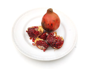 a fresh sweet pomegranate seed put in a white plate isolated on white background