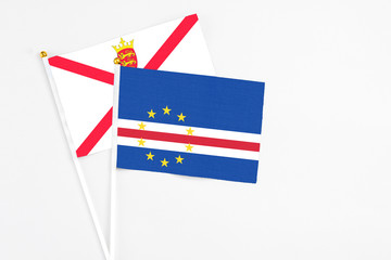 Cape Verde and Jersey stick flags on white background. High quality fabric, miniature national flag. Peaceful global concept.White floor for copy space.