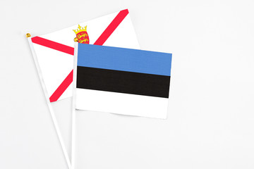 Estonia and Jersey stick flags on white background. High quality fabric, miniature national flag. Peaceful global concept.White floor for copy space.