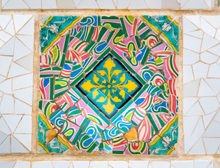 Barcelona, Spain - august 2019: mosaic on the wall, close up view. Abstract pattern, colourful background. Park Guell in Barcelona designed by Antonio Gaudi. Selective soft focus. Blurred background