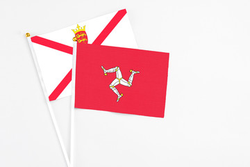 Isle Of Man and Jersey stick flags on white background. High quality fabric, miniature national flag. Peaceful global concept.White floor for copy space.