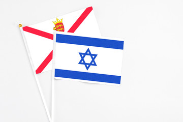 Fototapeta na wymiar Israel and Jersey stick flags on white background. High quality fabric, miniature national flag. Peaceful global concept.White floor for copy space.