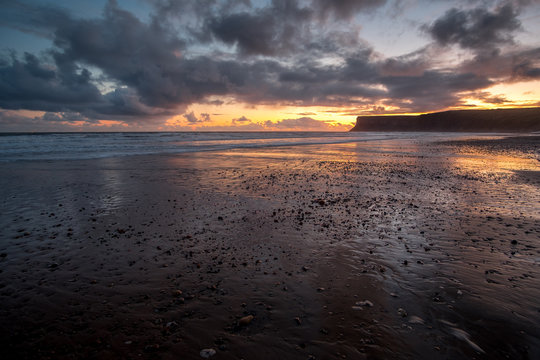 Sunrise over an empty beach on low tide at Saltburn by the sea