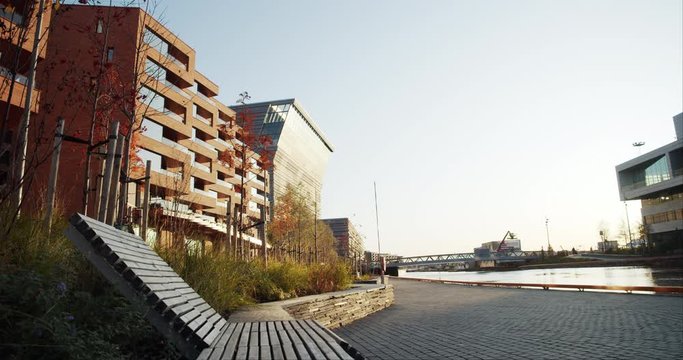 4K static low angle wide shot of Lambda, the new Edvard Munch museum, with famous paintings like The Scream, in an autumn sunset in the Bj&oslash;rvika quarter in Oslo, Norway.