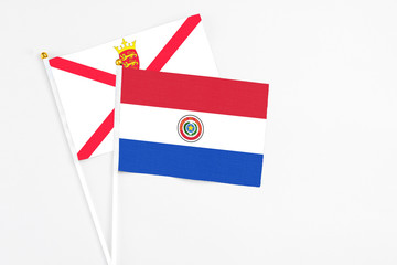 Paraguay and Jersey stick flags on white background. High quality fabric, miniature national flag. Peaceful global concept.White floor for copy space.