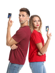 Young couple with credit cards on white background