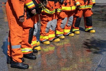Obraz premium Strong Firefighters in fireproof uniform and stand in line to prepare for extinguishing fires. Team work concept.