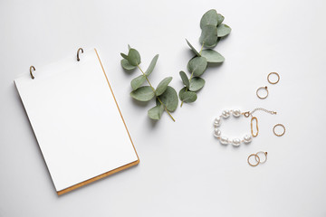 Stylish female jewelry with notebook on white background