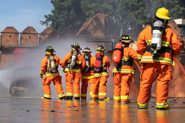 Firefighters are fighting fire with a fire brigade, Firefighters fighting fire during training with...