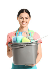 Female janitor with cleaning supplies on white background