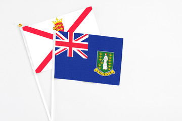 British Virgin Islands and Jersey stick flags on white background. High quality fabric, miniature national flag. Peaceful global concept.White floor for copy space.