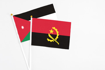 Angola and Jordan stick flags on white background. High quality fabric, miniature national flag. Peaceful global concept.White floor for copy space.