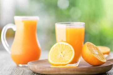 Glass of fresh orange juice on table outdoors