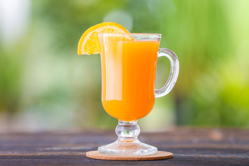 Glass cup of fresh orange juice on table outdoors