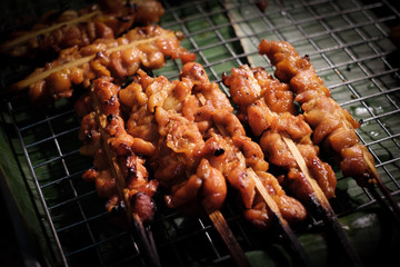 Ready-to-serve grilled chicken skewers on banana leaves