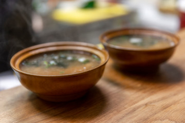 Plates with hot asian soup on the table. Close-up. Blurry.