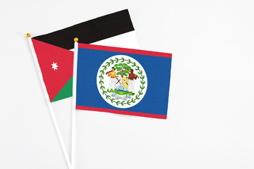 Belize and Jordan stick flags on white background. High quality fabric, miniature national flag. Peaceful global concept.White floor for copy space.