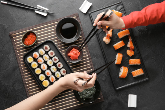 Women Eating Tasty Sushi At Table