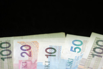 Polish zloty banknotes on a dark surface close-up. Money background green color toned