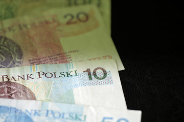 Polish zloty banknotes on a dark surface close-up. Money background green color toned