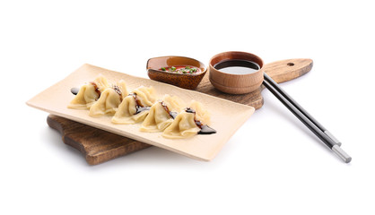 Plate with tasty Japanese gyoza sauces on white background