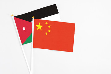 China and Jordan stick flags on white background. High quality fabric, miniature national flag. Peaceful global concept.White floor for copy space.