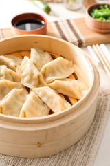 Bamboo steamer with tasty Japanese gyoza on table