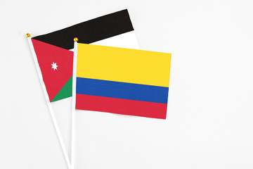 Colombia and Jordan stick flags on white background. High quality fabric, miniature national flag. Peaceful global concept.White floor for copy space.