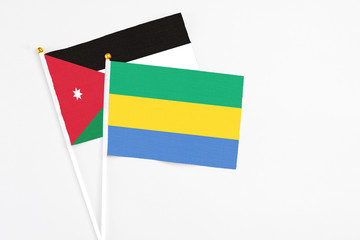 Gabon and Jordan stick flags on white background. High quality fabric, miniature national flag. Peaceful global concept.White floor for copy space.