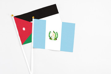 Guatemala and Jordan stick flags on white background. High quality fabric, miniature national flag. Peaceful global concept.White floor for copy space.