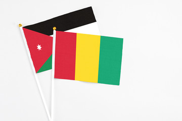 Guinea and Jordan stick flags on white background. High quality fabric, miniature national flag. Peaceful global concept.White floor for copy space.