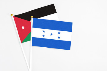 Honduras and Jordan stick flags on white background. High quality fabric, miniature national flag. Peaceful global concept.White floor for copy space.