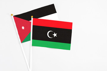 Libya and Jordan stick flags on white background. High quality fabric, miniature national flag. Peaceful global concept.White floor for copy space.