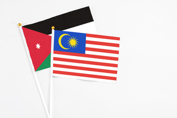 Malaysia and Jordan stick flags on white background. High quality fabric, miniature national flag. Peaceful global concept.White floor for copy space.