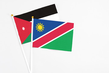 Namibia and Jordan stick flags on white background. High quality fabric, miniature national flag. Peaceful global concept.White floor for copy space.