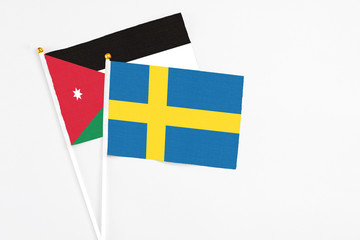 Sweden and Jordan stick flags on white background. High quality fabric, miniature national flag. Peaceful global concept.White floor for copy space.