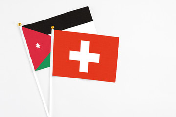 Obraz premium Switzerland and Jordan stick flags on white background. High quality fabric, miniature national flag. Peaceful global concept.White floor for copy space.