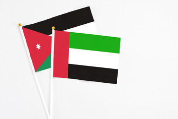 United Arab Emirates and Jordan stick flags on white background. High quality fabric, miniature national flag. Peaceful global concept.White floor for copy space.