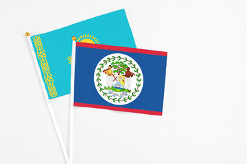Belize and Kazakhstan stick flags on white background. High quality fabric, miniature national flag. Peaceful global concept.White floor for copy space.